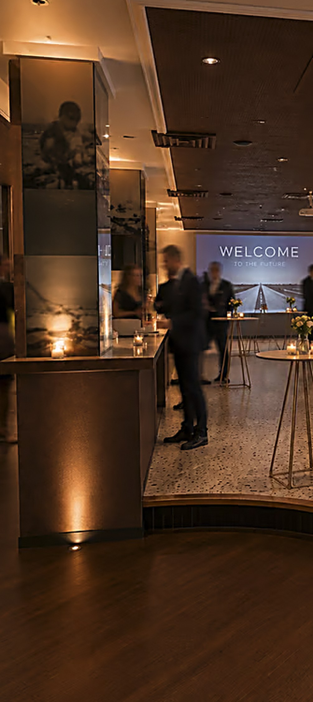 Donkere houten bar met kaarsen en bloemen in eventlocatie The Bel Air in Antwerpen
